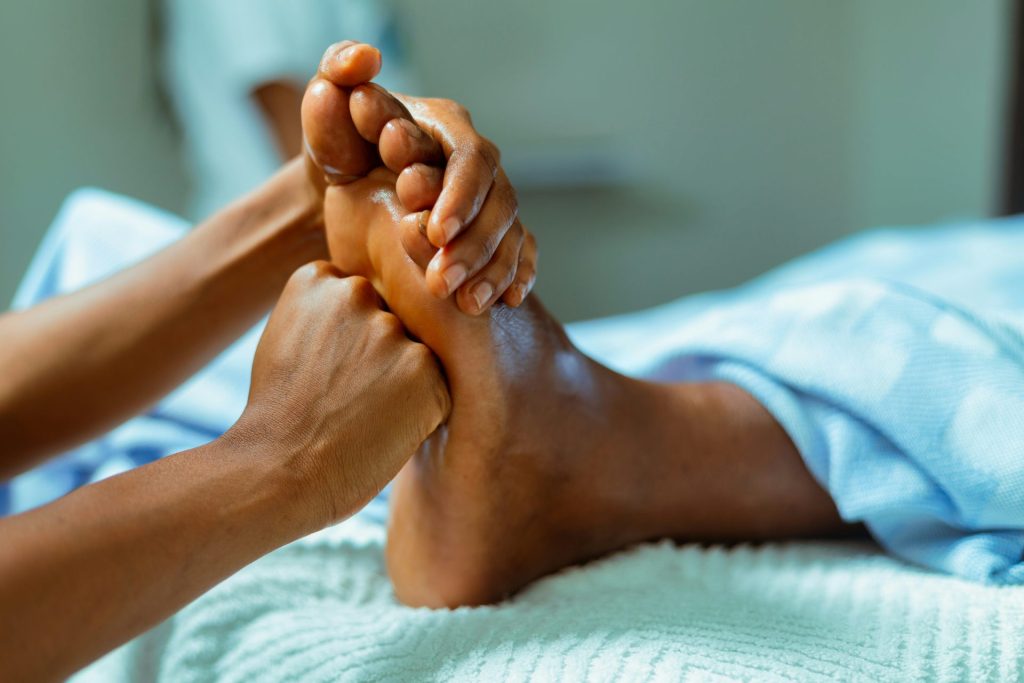 eine Person, die mit hochgelegten Füßen im Bett liegt